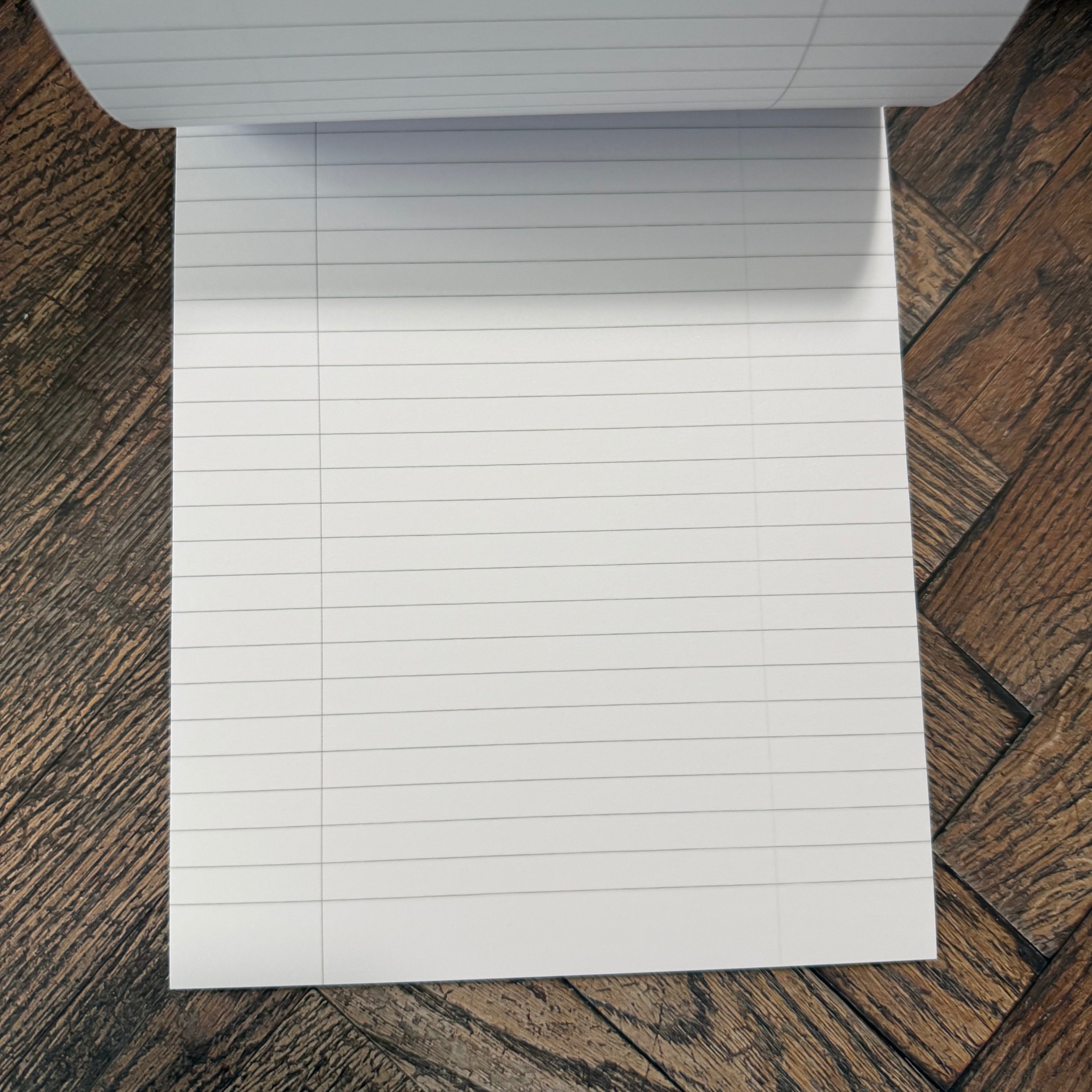 Open Rhodia Ice A5 notepad showing silver-grey horizontal ruling and a vertical left margin