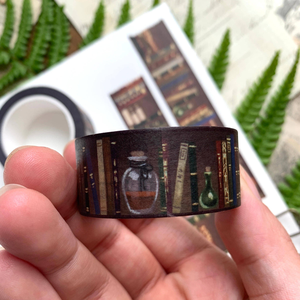 Roll of The Creeping Moon Bookshelf 20 mm washi tape held in hand