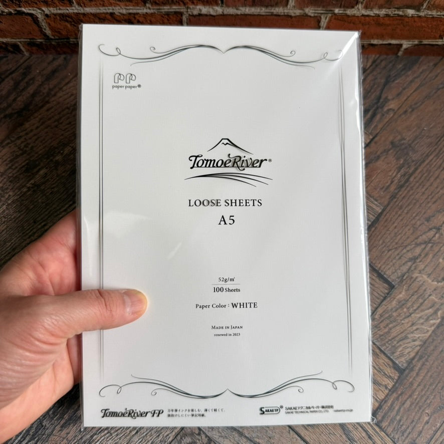 Hand holding a Tomoe River FP A5 loose sheets pack of 100 white 52 gsm sheets for scale