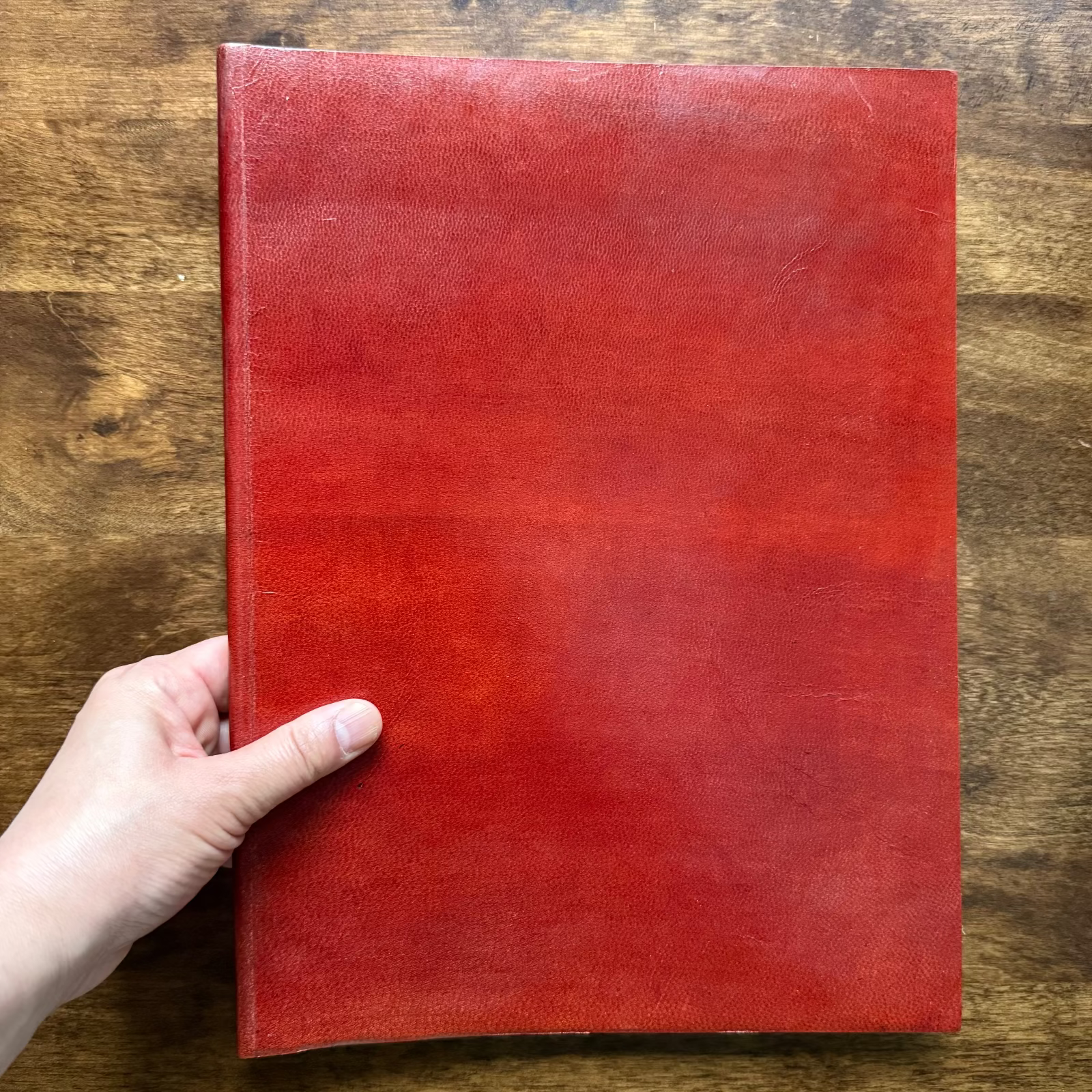 Tri-Art leatherbound mixed media artist book held in hand to show size and binding