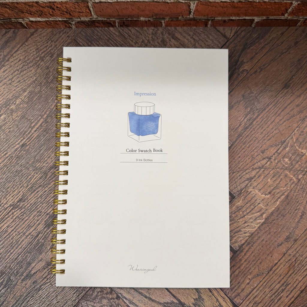 Wearingeul Impression A5 ink color swatch book with white cover, blue ink-bottle illustration, and gold-tone wire binding