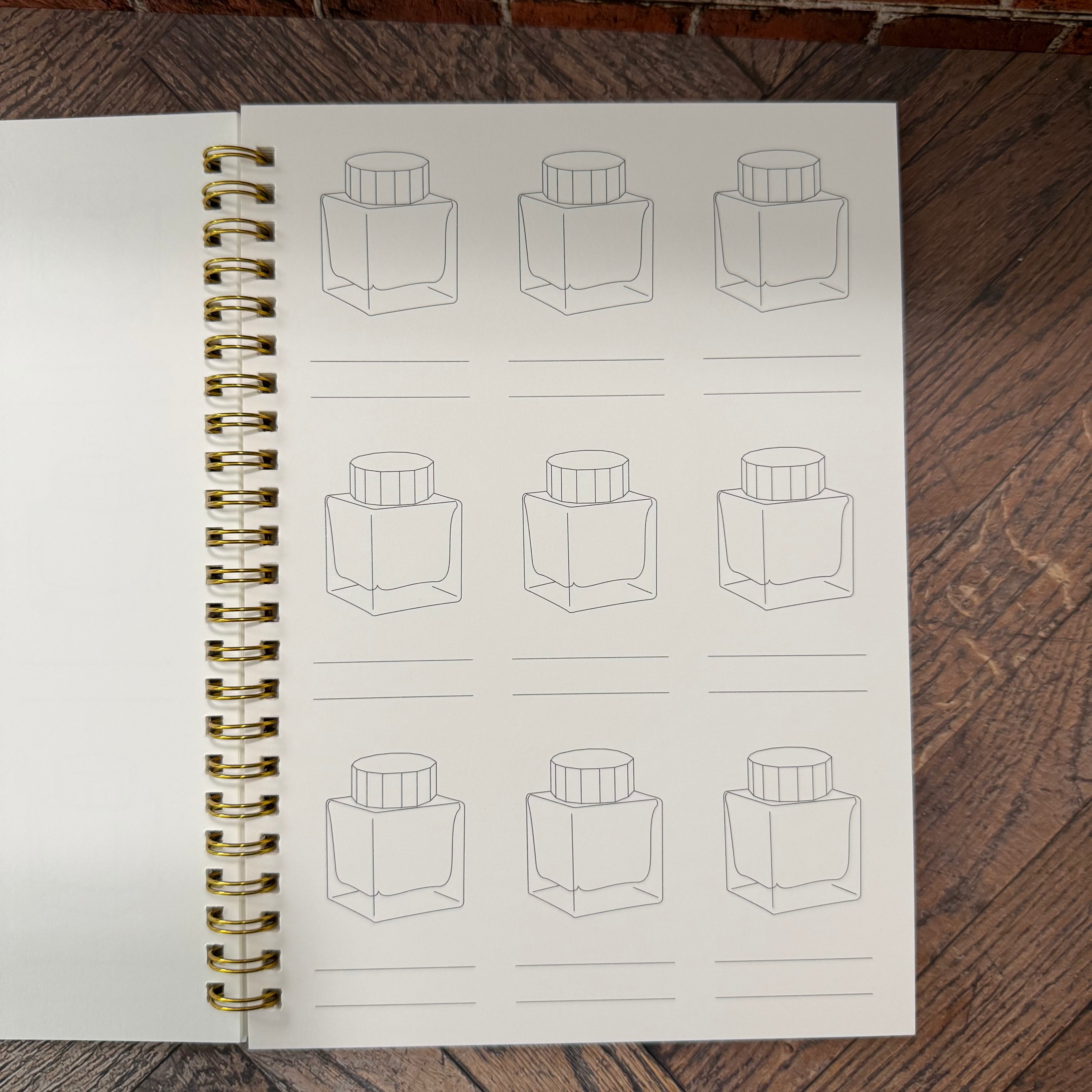 Open Wearingeul swatch book showing nine ink-bottle outlines with two writing lines beneath each bottle