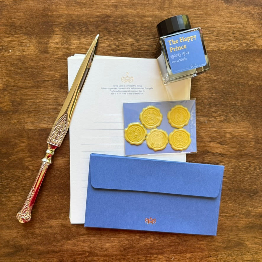 The Happy Prince Letter Writing Set with blue envelope, writing paper, and decorative gold seals